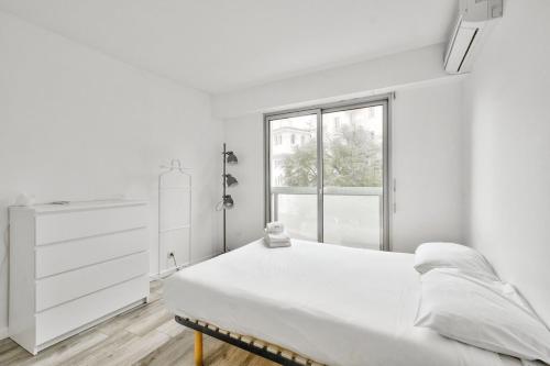 une chambre blanche avec un lit et une fenêtre dans l'établissement Flat with balcony 15min from Promenade des Anglais, à Nice