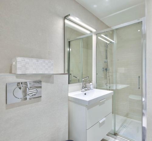 une salle de bain blanche avec un lavabo et une douche dans l'établissement Flat with balcony 15min from Promenade des Anglais, à Nice