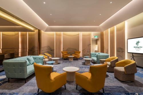 a waiting room with furniture and a flat screen tv at Holiday Inn Pattaya by IHG in Pattaya Central