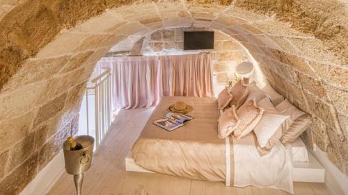 a bedroom with a bed in a stone wall at New Dimora Valmar in Polignano a Mare
