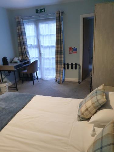a bedroom with a bed and a desk in a room at Lime Tree Hotel in Fort William