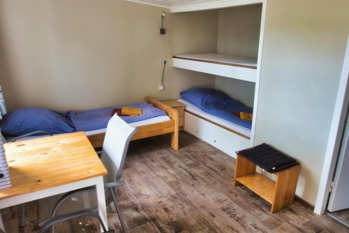 a room with bunk beds and a desk and a table at Finnenhaus 7 in Lübeck