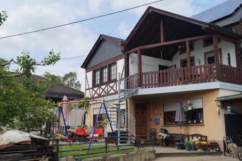 a house with a balcony and a porch at familienfreundliche Ferienwohnung Weingarten in Piesport in Piesport