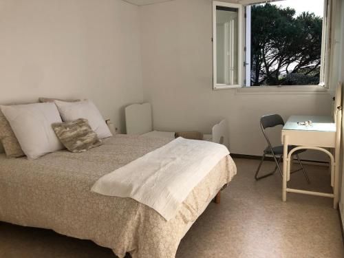 une chambre avec un lit, un bureau et une fenêtre dans l'établissement Confortable appartement 5 pers, 900m plage et commerces, à Sainte-Maxime