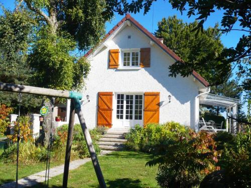 a small white house with orange doors in a yard at Gite la fougère vue sur la campagne in Verrières-en-Forez