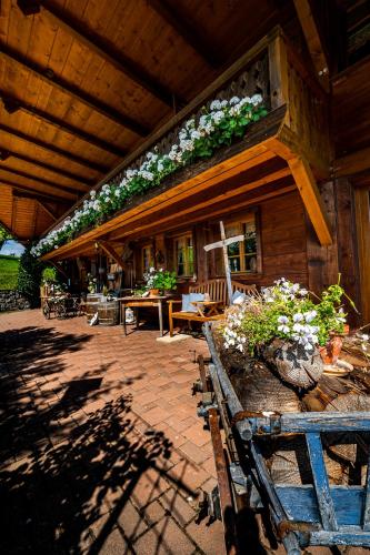 a porch of a wooden house with plants on it at Gästehaus Holzer Kreuz - Ferienwohnung "Narzisse" in Fröhnd