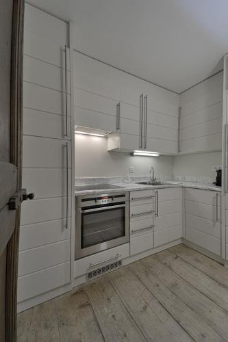 a kitchen with white cabinets and a stainless steel oven at Alte Scheune - Samedan in Samedan