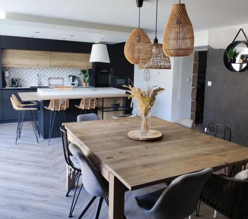 une cuisine et une salle à manger avec une table et des chaises en bois dans l'établissement Grande maison familiale avec piscine, à Saint-Ouen-des-Alleux