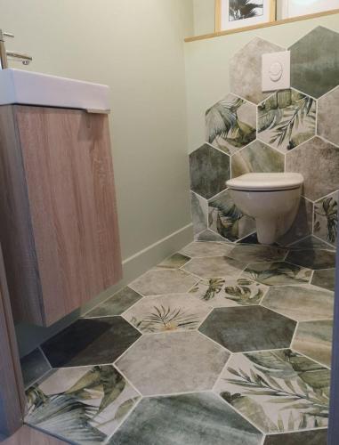 La salle de bains est pourvue de toilettes et d'un mur en pierre. dans l'établissement Grande maison familiale avec piscine, à Saint-Ouen-des-Alleux