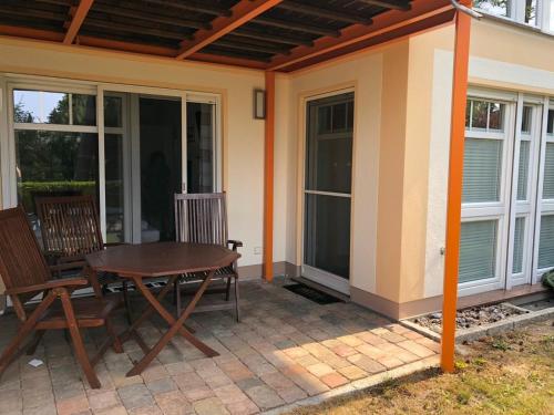 Un patio con una mesa y sillas al lado de una casa. en Whg-2- Bella Casa, en Baabe