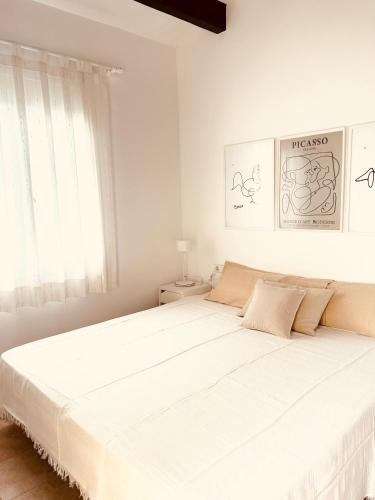 a white bedroom with a large white bed at Ca' na Cocca - Chalet con piscina privata in Cala en Bosc