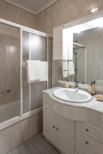a white bathroom with a sink and a shower at Biarritz - Varanda da Ria in Costa Nova