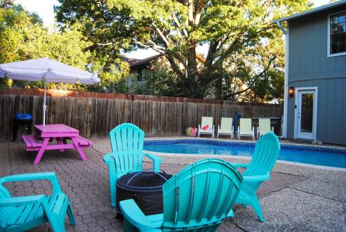 een groep stoelen en een grill naast een zwembad bij The Cowboy Cabana in Round Rock