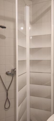 une douche avec une porte vitrée dans une salle de bain dans l'établissement Studios - Centre ville coeur historique, à Arles