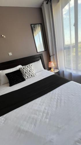 a bedroom with a large white bed with a window at FlexHomes-Ongata Rongai in Ongata Rongai 