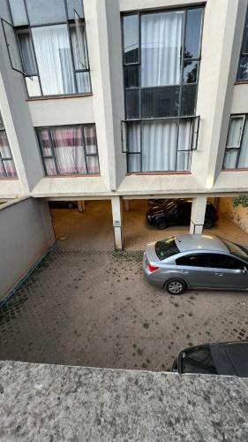 a car parked in a parking lot between two buildings at FlexHomes-Ongata Rongai in Ongata Rongai 