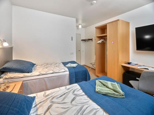 a hotel room with two beds and a television at Hotelli-Ravintola Gasthaus Lohja in Lohja