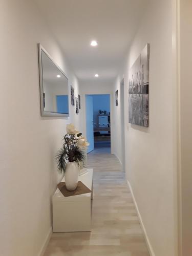 a hallway with a vase of flowers on a table at Ferienwohnung Weiland 60qm in Lutherstadt Eisleben