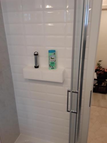 a white wall with a shelf and a bottle on it at Ferienwohnung Weiland 60qm in Lutherstadt Eisleben
