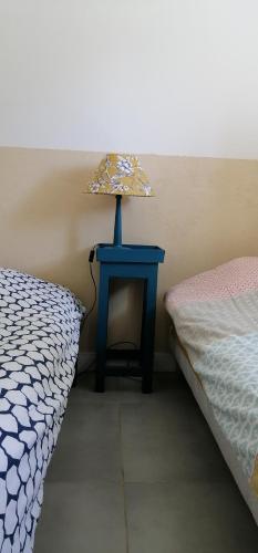 une table bleue avec une lampe placée à côté d'un lit dans l'établissement Petite Maison Marie-Louise, à Saint-Vallier-de-Thiey