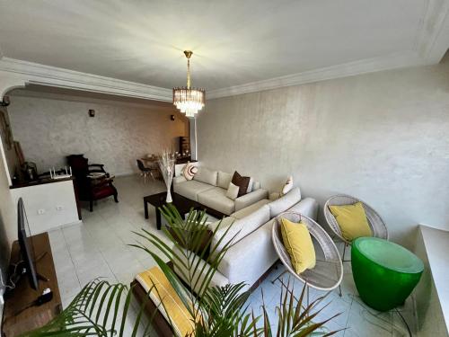 una sala de estar con un sofá y sillas en Bel appartement avec une belle vue sur la grande mosquée Hassan II et la mer, en Casablanca