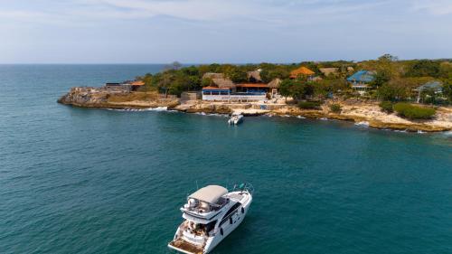 a boat in the water next to a small island at Hotel Isla Real in Tierra Bomba