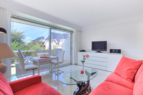 a living room with a red couch and a glass table at Windeby 4E in Wenningstedt
