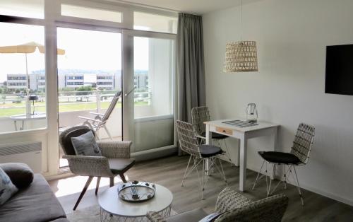 Una sala de estar con un sofá y sillas y una mesa. en Strandbude Fehmarn, en Fehmarn