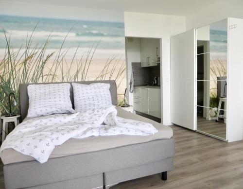 Un dormitorio con una cama con vistas a la playa. en Strandbude Fehmarn, en Fehmarn