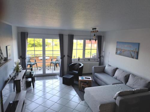 a living room with a couch and a table at Haus Sonnenstrahl 11 in Dorum-Neufeld