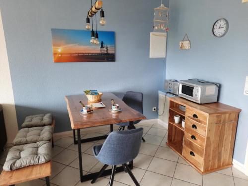 a kitchen with a wooden table and a microwave at Haus Sonnenstrahl 11 in Dorum-Neufeld