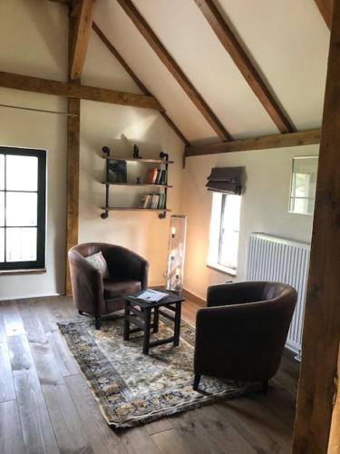 a living room with two chairs and a table at Scheune Zauchwitz in Beelitz
