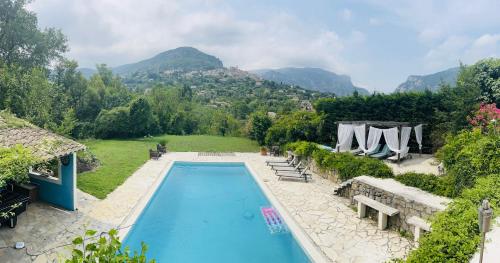 une piscine avec des montagnes en arrière-plan dans l'établissement 5 Bedroom Villa with magnificent views, à Le Bar-sur-Loup