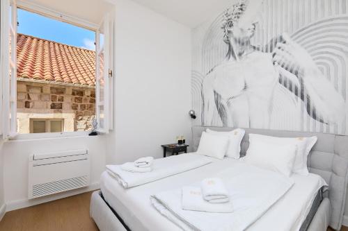 a bedroom with a white bed with a large window at TUDISI LUX SUITES by DOMINIUM in Dubrovnik