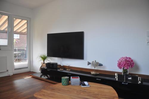 a living room with a flat screen tv on a wall at Am Alten Leuchtfeuer in Eckernförde