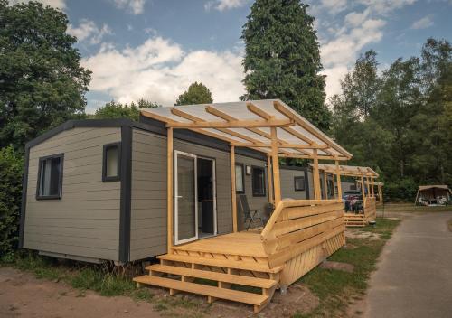 a tiny house with a porch and a deck at Camping Bad Liebenzell in Bad Liebenzell