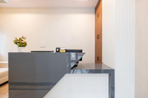 a kitchen with a counter with a vase of flowers at R D HOTELS Peenya in Bengaluru