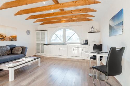 a living room with a couch and a table at Ferienwohnung Seestern mit Rundbogenfenster am Badesee Tannenhausen in Aurich