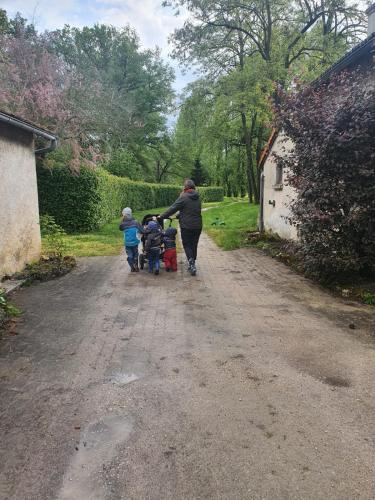 a woman and two children walking down a dirt road at Gîte Le Bois Clairet in Journet