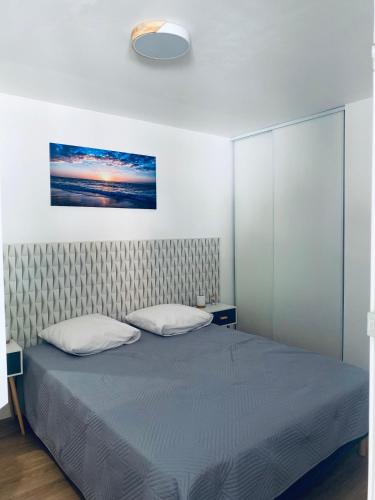 une chambre avec un lit et un tableau au mur dans l'établissement Superbe appartement climatisé avec wifi classé 3 étoiles à 50 m de la plage Le Lavandou, au Lavandou