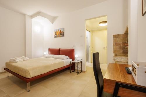 a bedroom with a bed and a table and a desk at Casa Nostrana in Chioggia
