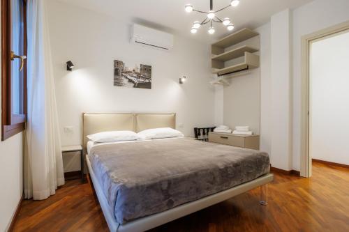 a bedroom with a bed and a chandelier at Casa Nostrana in Chioggia