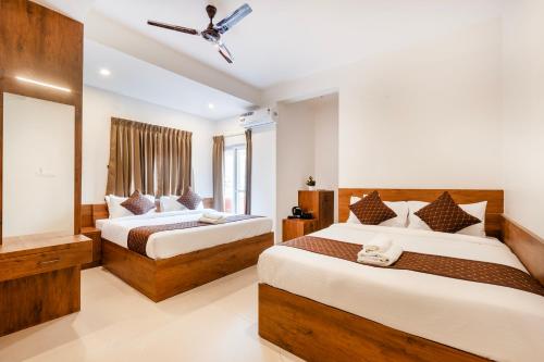 a hotel room with two beds and a window at R D HOTELS Peenya in Bengaluru