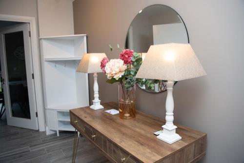 a table with two lamps and a vase of flowers at Luxury 3 bed town house Dog friendly in Donegal