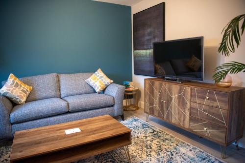 a living room with a couch and a flat screen tv at Luxury 3 bed town house Dog friendly in Donegal