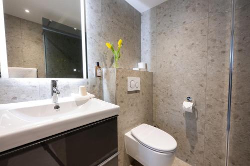 a bathroom with a sink and a toilet and a shower at Hotel Royal in Noordwijk