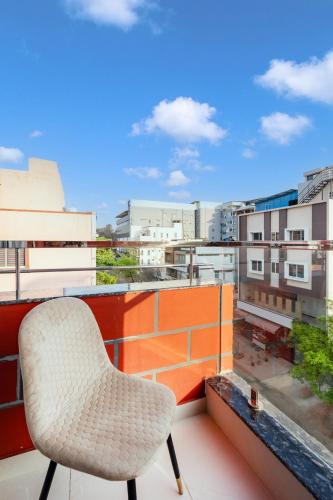 a chair on a balcony with a view of a city at R D HOTELS Peenya in Bengaluru