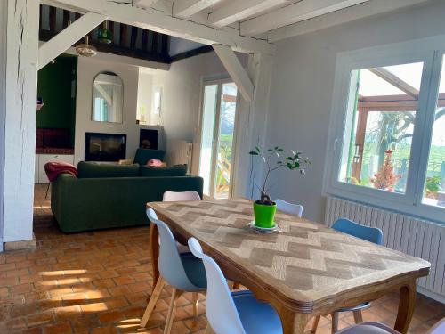 un salon avec une table et des chaises en bois dans l'établissement La paisible, maison familiale et conviviale en Baie de Somme, à Vaudricourt