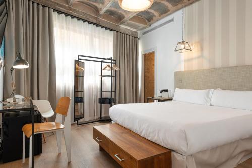 a bedroom with a bed and a desk and a chair at Brondo Architect Hotel in Palma de Mallorca