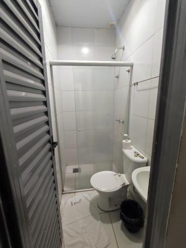 a small bathroom with a toilet and a shower at Shopping 44 Hotel in Goiânia